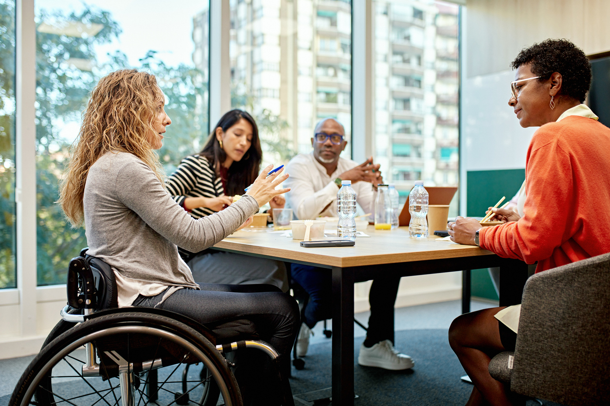 A diverse group of individuals sitting around a table, discussing.